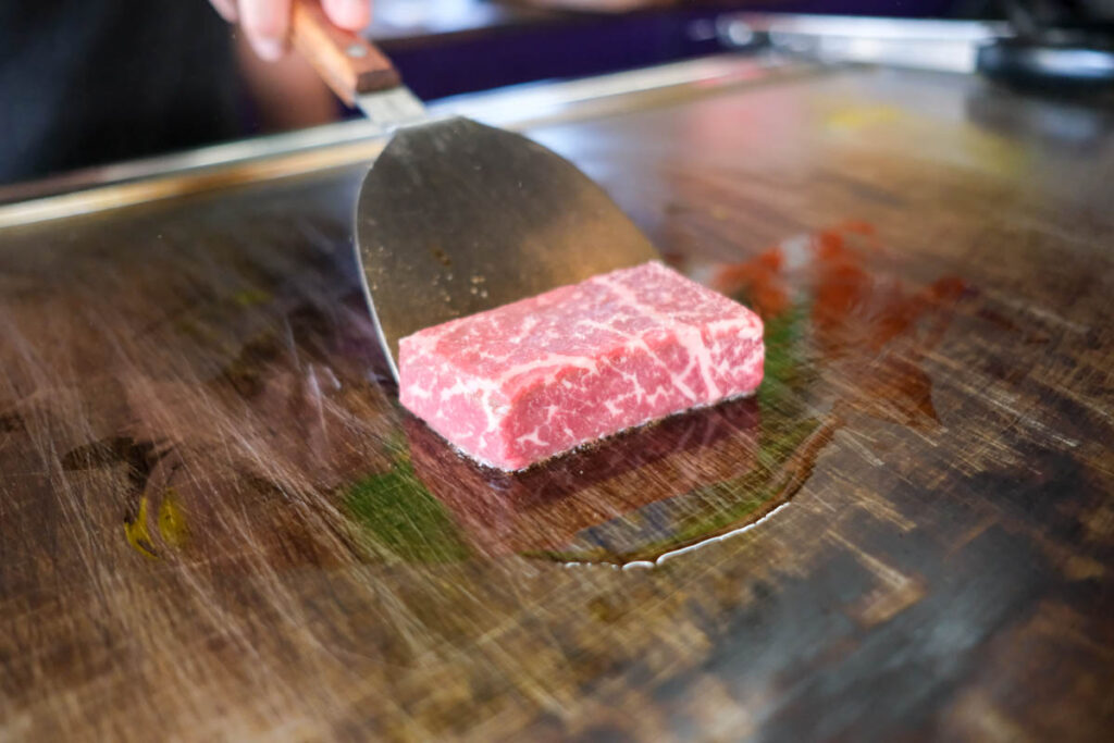 意気感ステーキ丼の肉を鉄板で焼いているところ